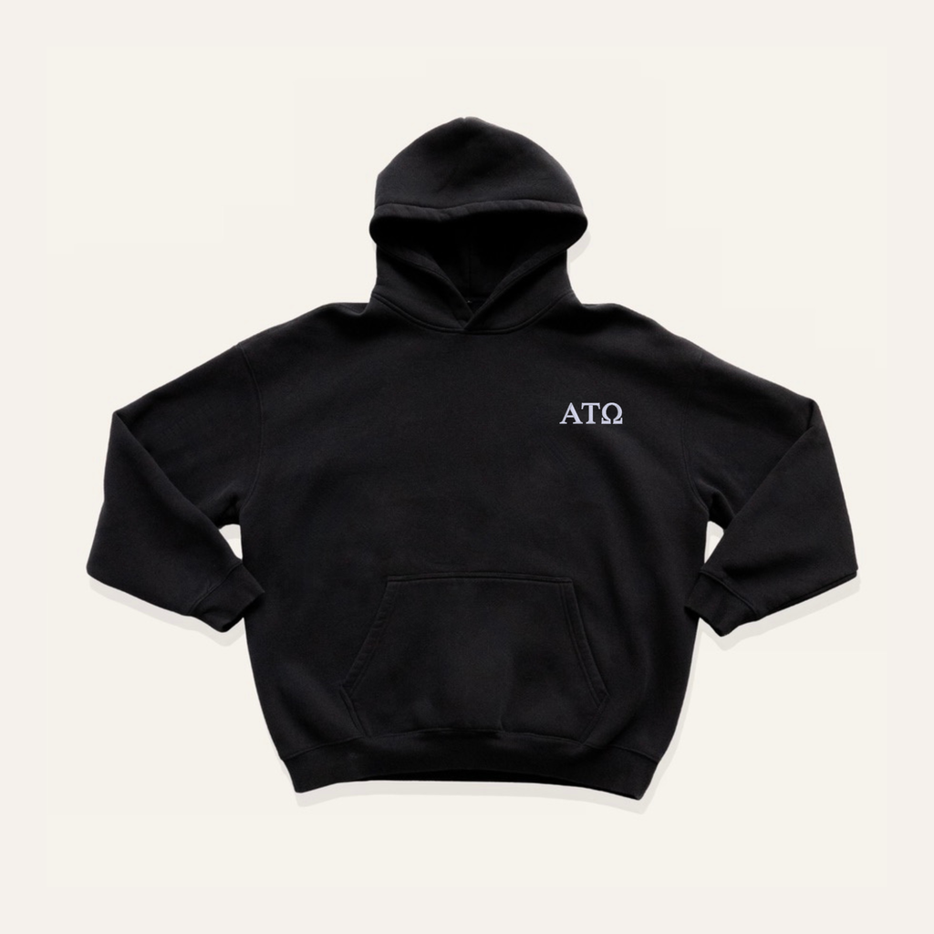 Black hoodie on a cream background with 'Alpha Tau Omega' greek letters in white on the left side chest.