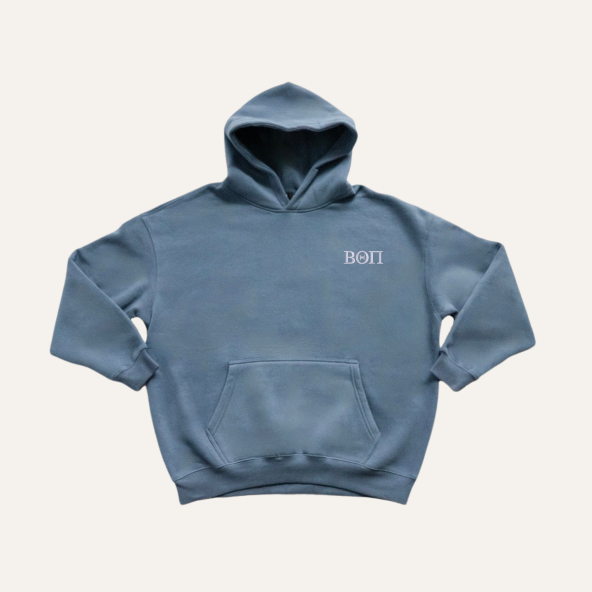 Dusty blue hoodie on a cream background with 'Beta Theta Pi' greek letters in white on the left side chest.