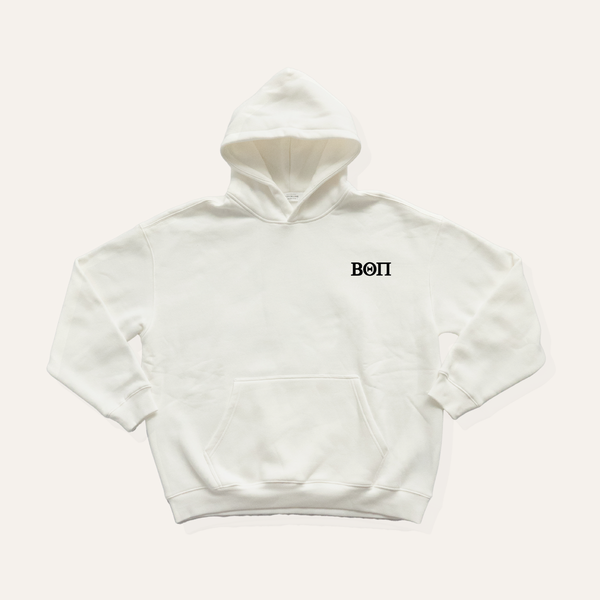 White hoodie on a cream background with 'Beta Theta Pi' greek letters in black on the left side chest.