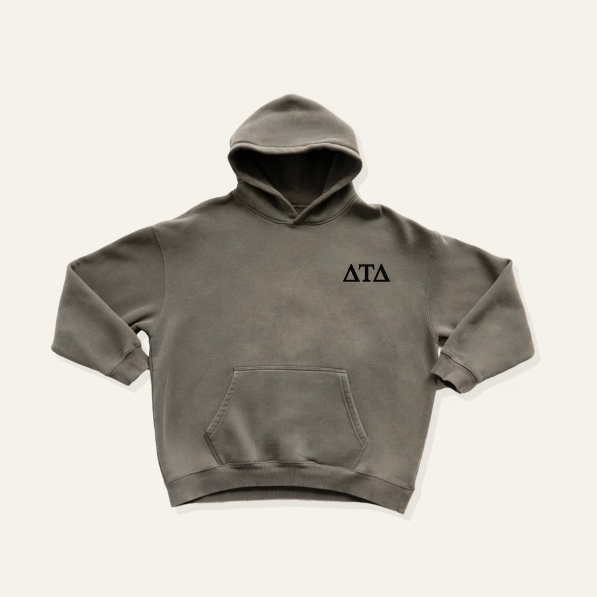 Grey hoodie on a cream background with 'Delta Tau Delta' greek letters in black on the right side chest.