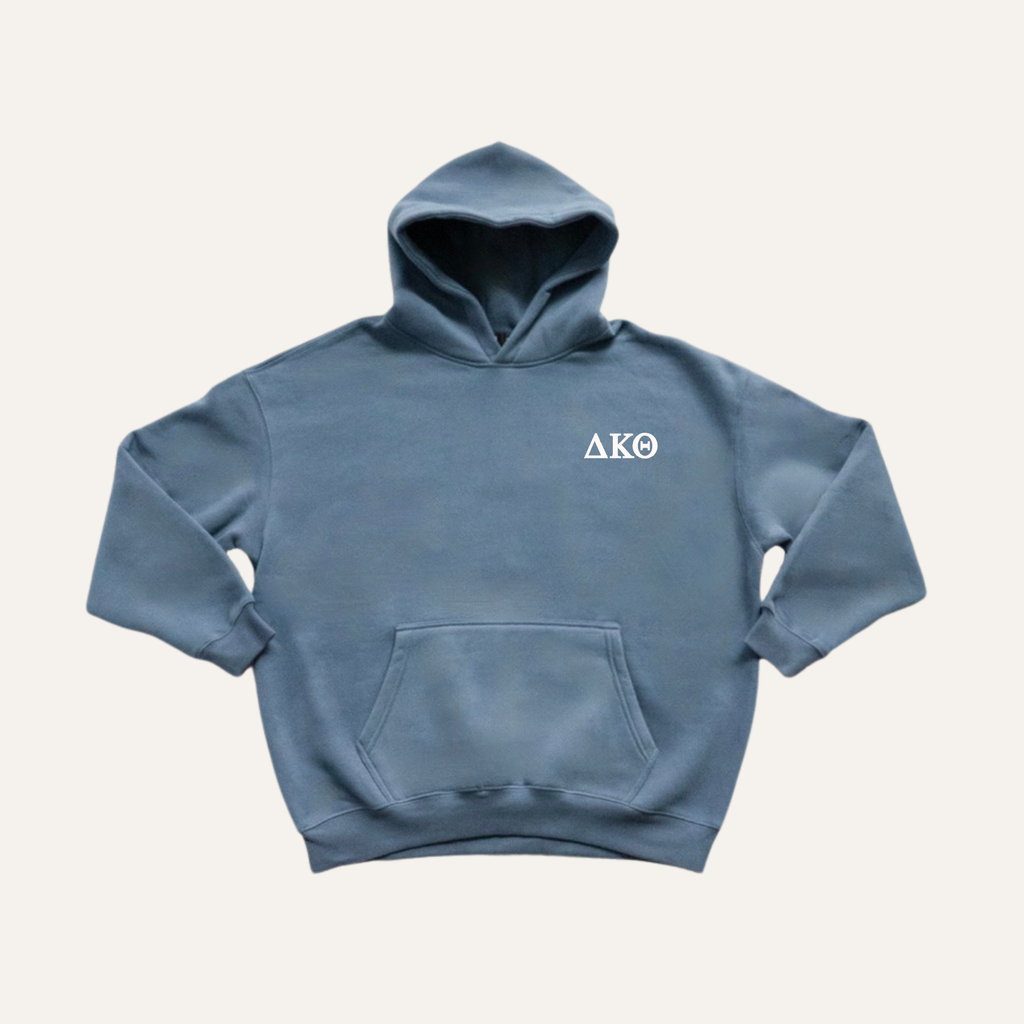 Dusty blue hoodie on a cream background with 'Delta Kappa Theta' greek letters on the right side near the hood in white lettering.
