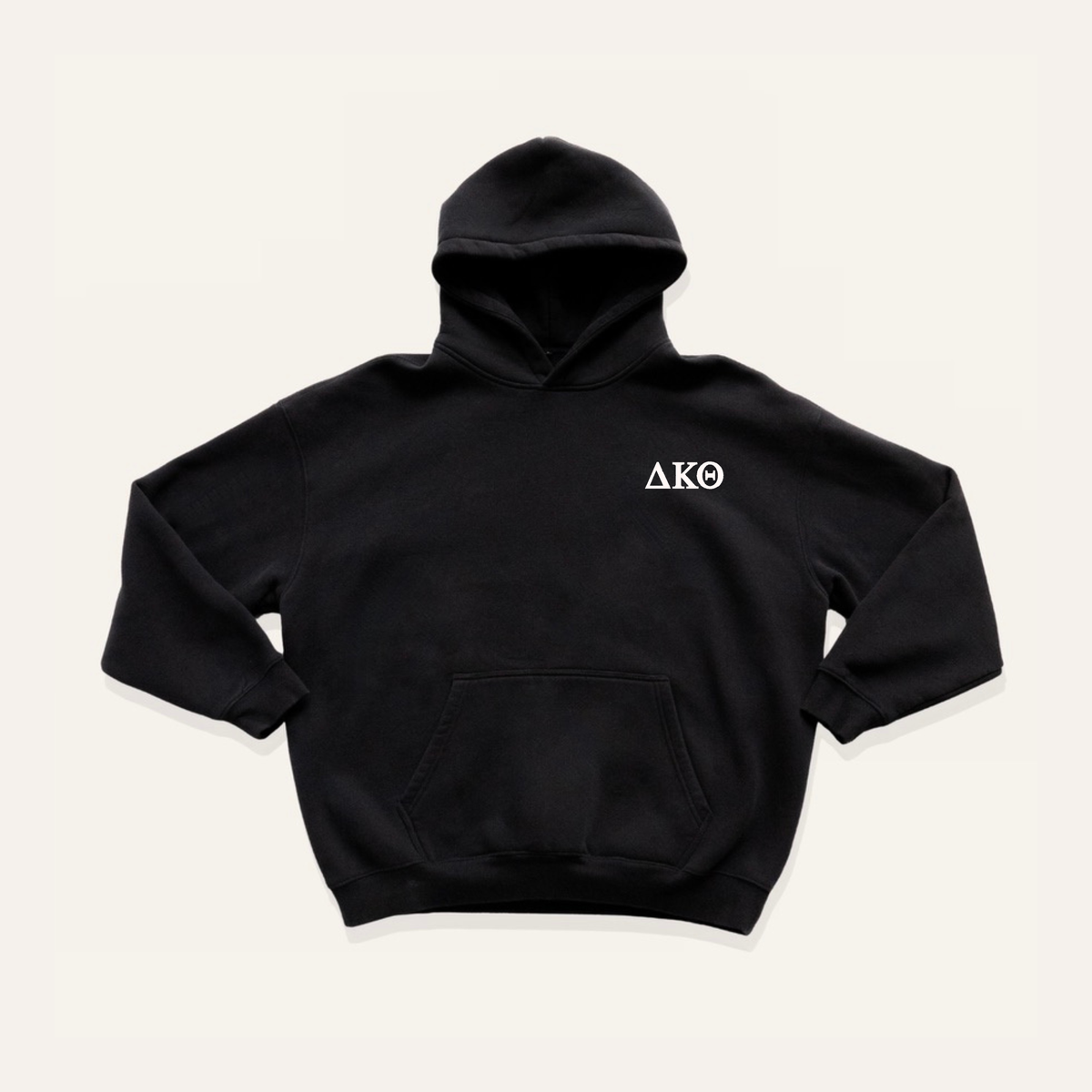 Black hoodie on a cream background with 'Delta Kappa Theta' greek letters on the right side near the hood.