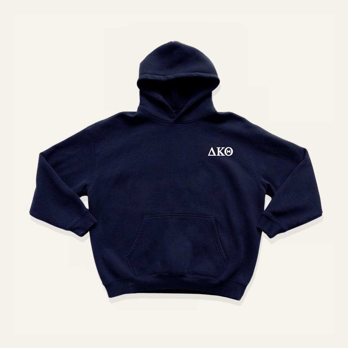 Navy hoodie on a cream background with 'Delta Kappa Theta' greek letters on the right side near the hood in white lettering.