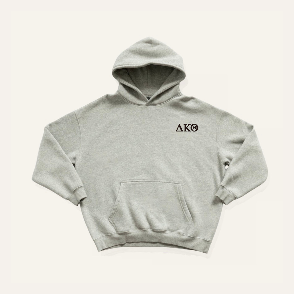 Light grey hoodie on a cream background with 'Delta Kappa Theta' greek letters on the right side near the hood in black lettering.