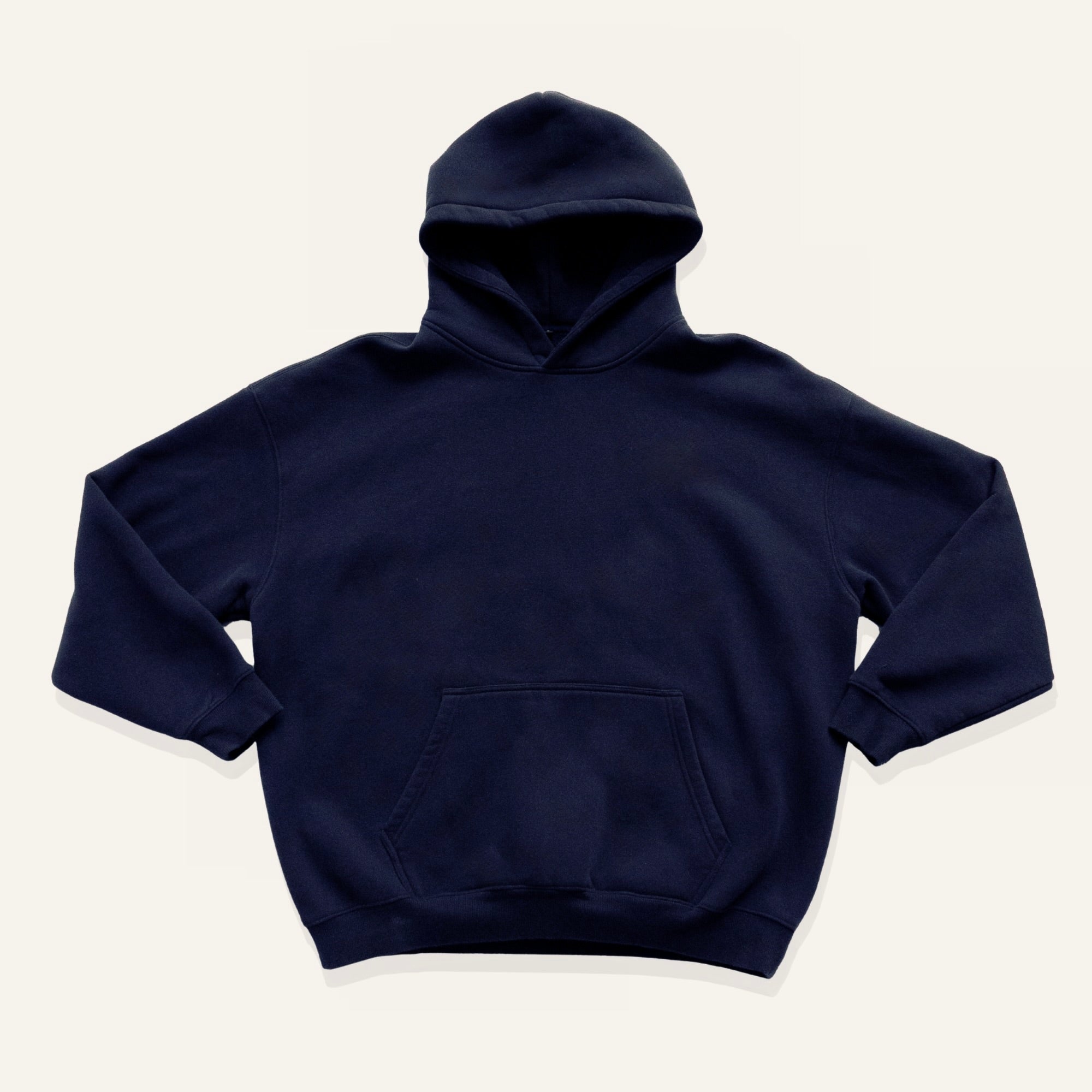 Navy hoodie on a cream background