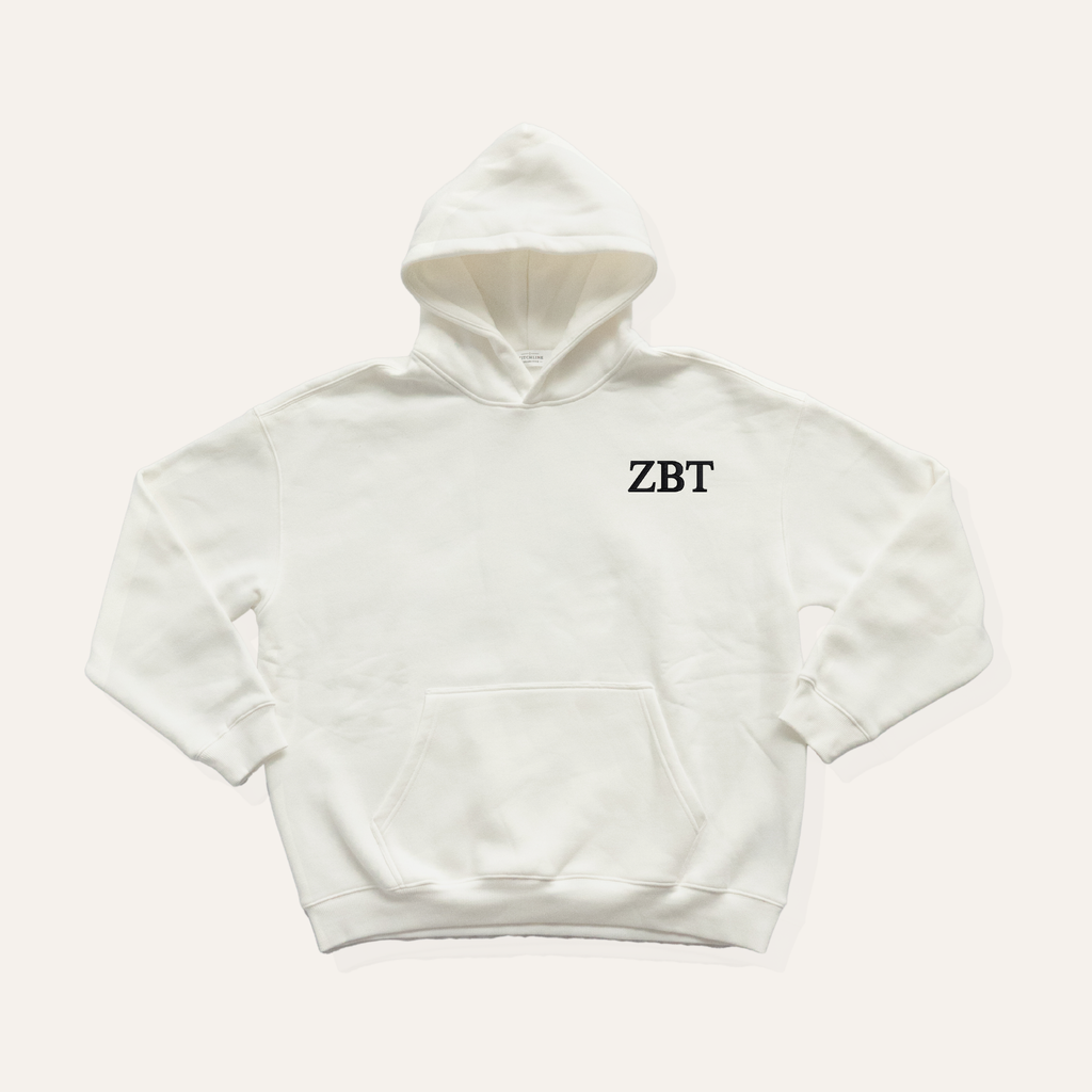 White hoodie on a cream background with 'Zeta Beta Tau' greek letters on the right side near the hood in black lettering.